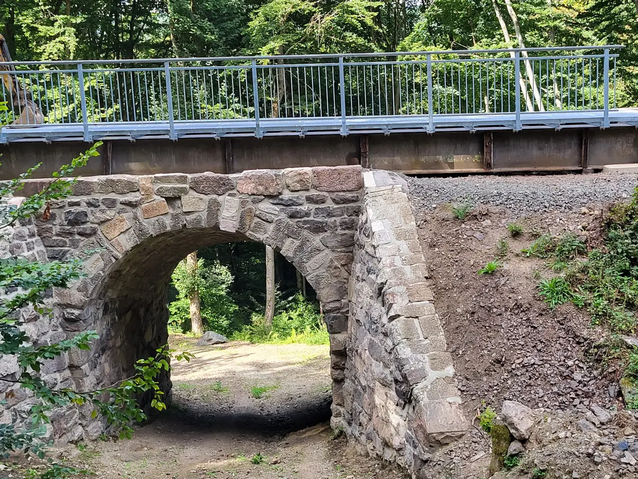 Verzinktes Geländer auf einer Natursteinbrücke