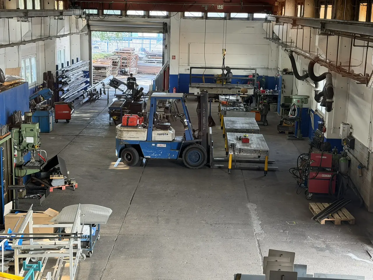 Blick von oben in die Fertigungshalle mit Gabelstapler und Maschinen