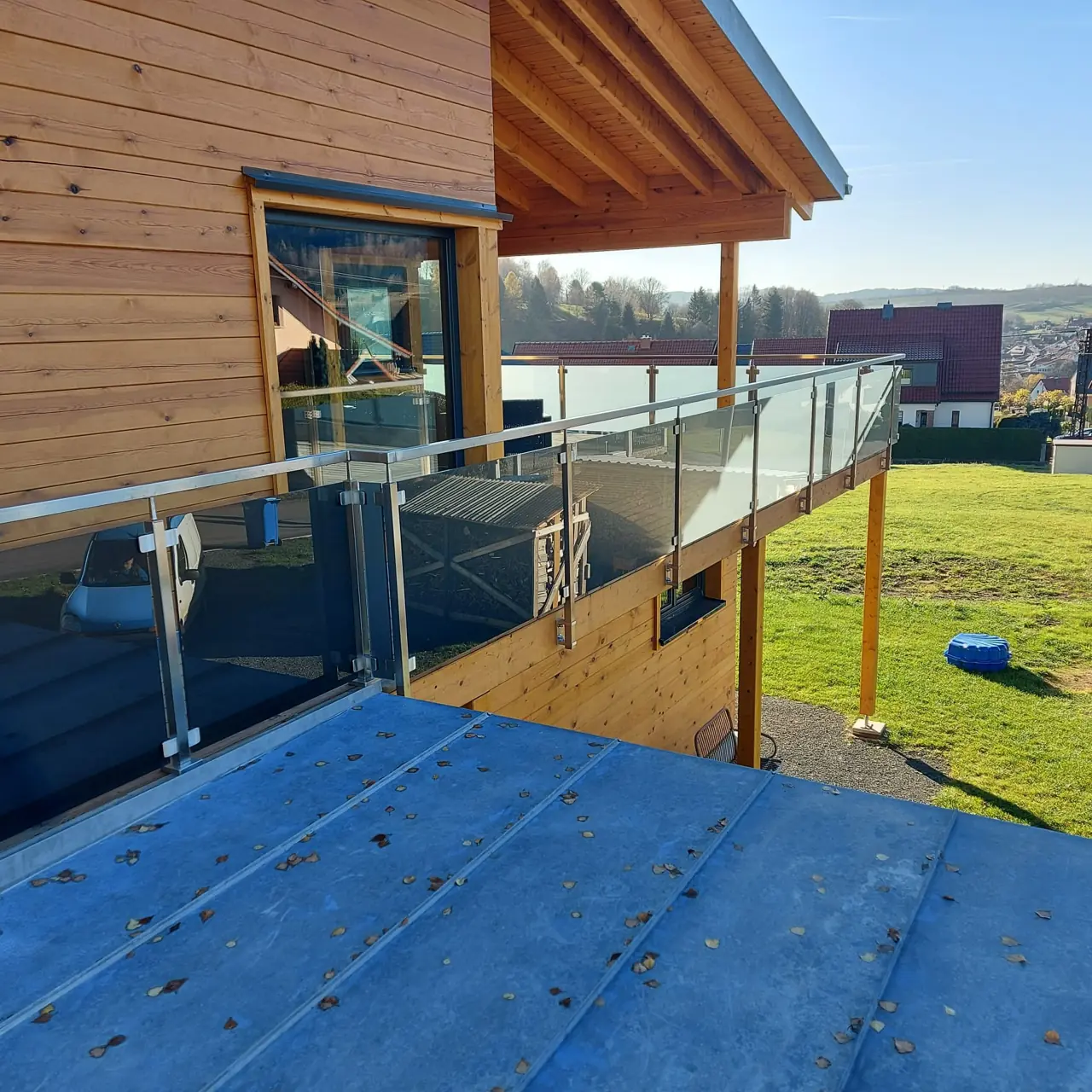 Balkon mit Glasgeländer an einem Holzhaus