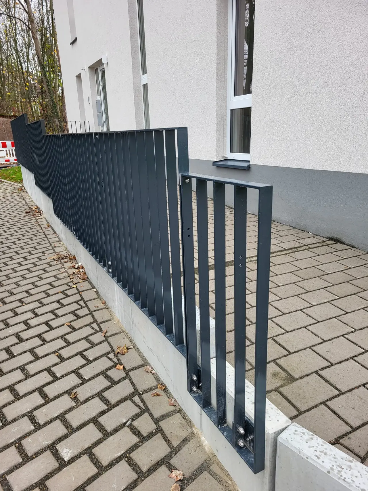 Stabzaun in Anthrazit entlang eines Gebäudes